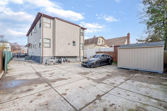 exterior space featuring fence, a patio, an outdoor structure, and a shed