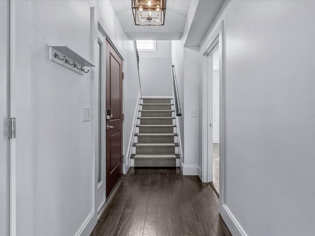 hallway with dark wood finished floors, baseboards, and stairs