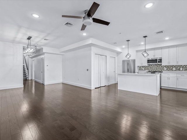 141 Marina Pointe Dr, East Rockaway, NY 11518 - unfurnished living room with ceiling fan with notable chandelier, dark wood finished floors, visible vents, and recessed lighting