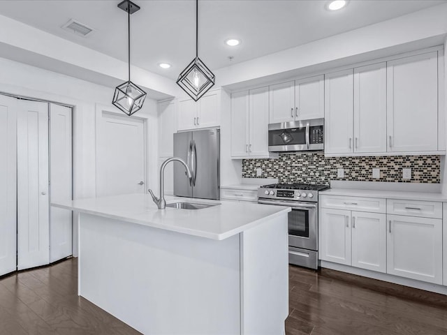 141 Marina Pointe Dr, East Rockaway, NY 11518 - kitchen featuring appliances with stainless steel finishes, an island with sink, white cabinets, and pendant lighting