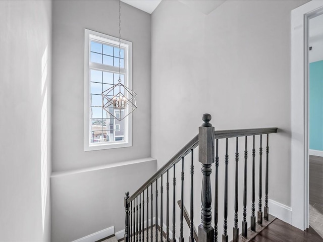 141 Marina Pointe Dr, East Rockaway, NY 11518 - staircase featuring a notable chandelier, baseboards, and wood finished floors