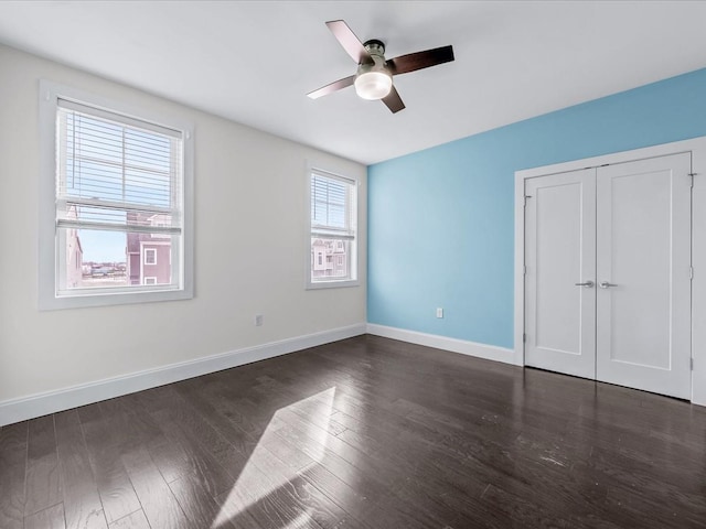 141 Marina Pointe Dr, East Rockaway, NY 11518 - unfurnished bedroom featuring dark wood-style flooring, a closet, a ceiling fan, and baseboards