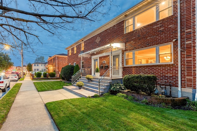 view of front of home with a front yard and brick siding