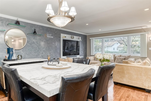 dining space featuring a notable chandelier, light wood-style flooring, crown molding, and recessed lighting