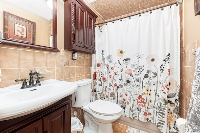 bathroom with toilet, a shower with shower curtain, vanity, and tile walls