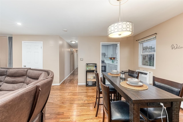 dining space with light wood-type flooring and baseboards