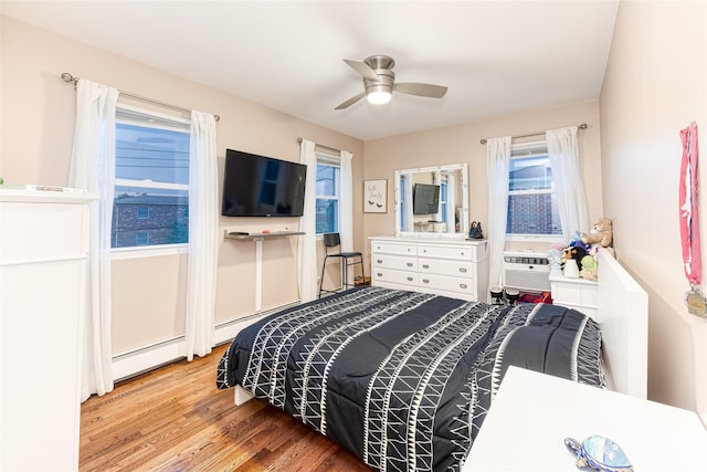 bedroom featuring a ceiling fan, cooling unit, and wood finished floors