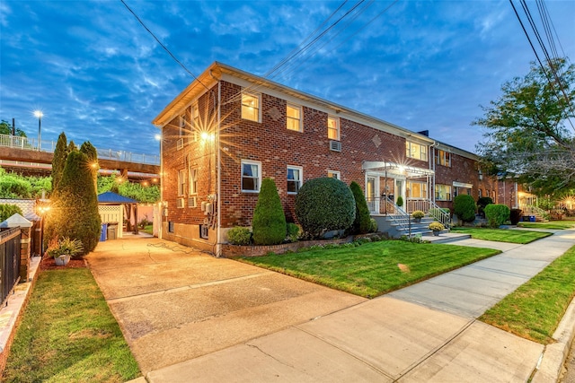 view of front facade featuring fence, a front lawn, and brick siding