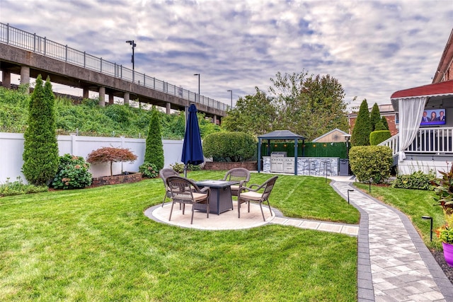 view of yard featuring a fire pit, a patio, and fence