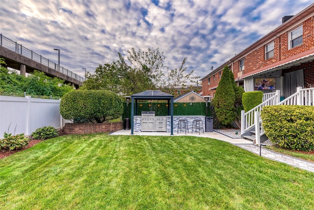 view of yard featuring fence, outdoor dry bar, exterior kitchen, and a patio