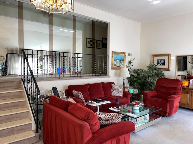 carpeted living room featuring an inviting chandelier and stairs