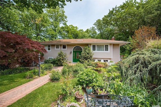 bi-level home with a front lawn and a chimney