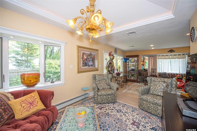 living room featuring visible vents, a baseboard heating unit, ornamental molding, wood finished floors, and a chandelier