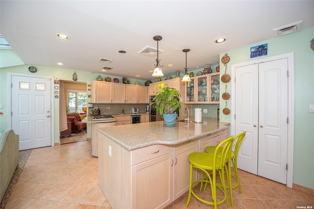 kitchen featuring a kitchen island, backsplash, and visible vents