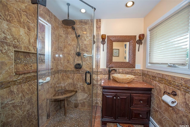 bathroom with a stall shower, wainscoting, vanity, tile walls, and recessed lighting