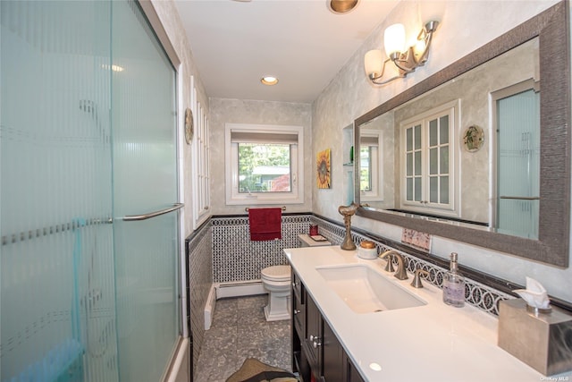 full bath featuring toilet, a shower with door, a baseboard heating unit, and vanity