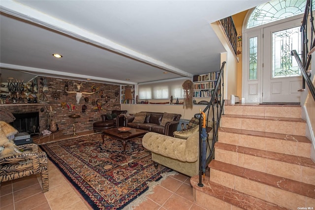 tiled living area featuring stairway and a brick fireplace