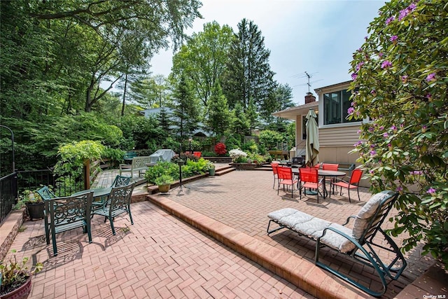 view of patio / terrace featuring entry steps, fence, and outdoor dining area