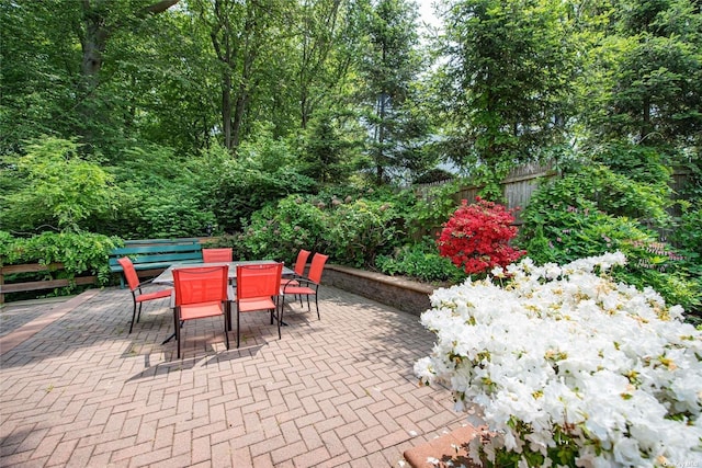 view of patio with outdoor dining space and fence