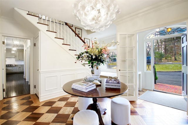 dining space with plenty of natural light, a chandelier, a decorative wall, and ornamental molding