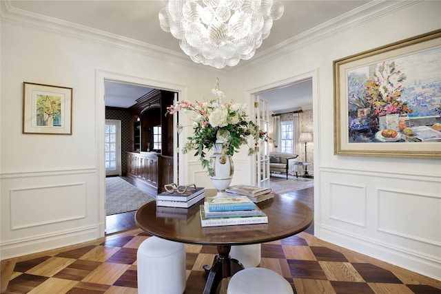 dining room with crown molding, a decorative wall, and a notable chandelier