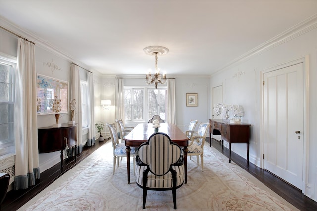 dining area with an inviting chandelier, light wood-style flooring, baseboards, and crown molding