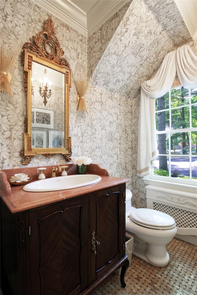 half bath with toilet, vanity, radiator, wallpapered walls, and crown molding