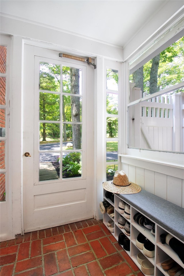 doorway to outside with brick floor and a healthy amount of sunlight