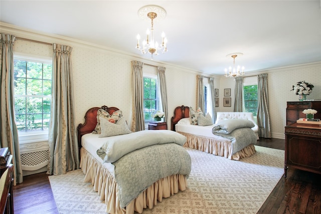 bedroom with an inviting chandelier, ornamental molding, wood finished floors, multiple windows, and wallpapered walls