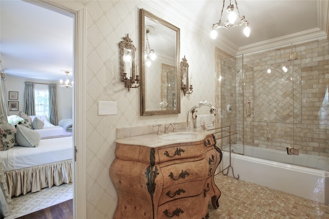 bathroom featuring vanity, ornamental molding, combined bath / shower with glass door, ensuite bath, and an inviting chandelier