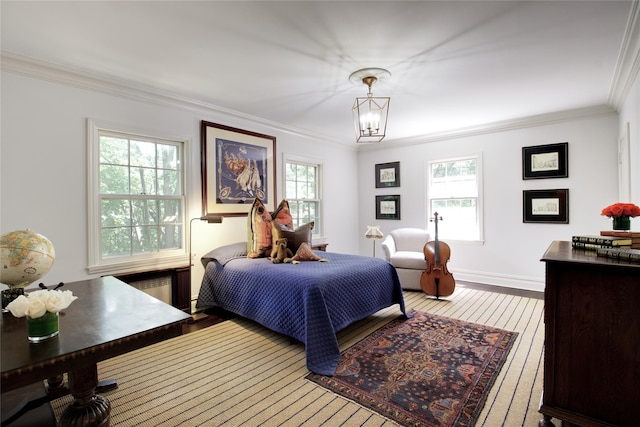 bedroom with crown molding, radiator, wood-type flooring, a chandelier, and baseboards