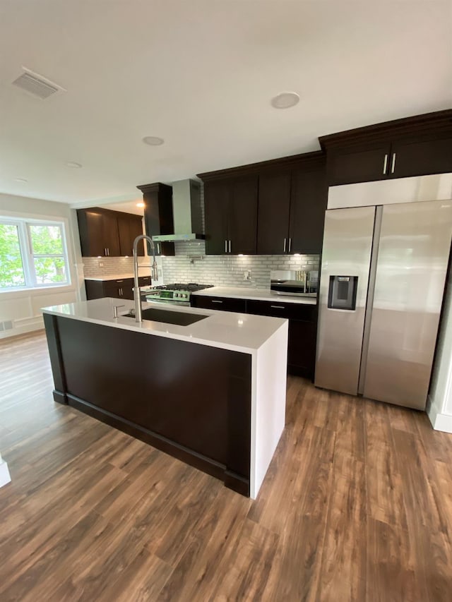 kitchen with wood finished floors, visible vents, light countertops, stainless steel refrigerator with ice dispenser, and decorative backsplash