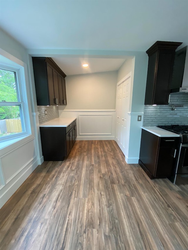 kitchen featuring dark wood-style floors, stainless steel range with gas cooktop, light countertops, and dark brown cabinets