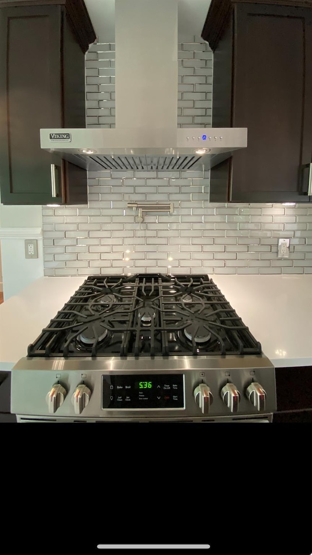 kitchen featuring dark brown cabinetry and wall chimney range hood