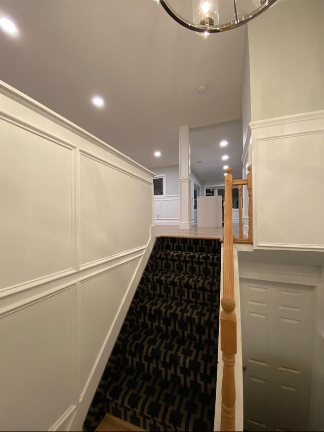 hall featuring a decorative wall and recessed lighting