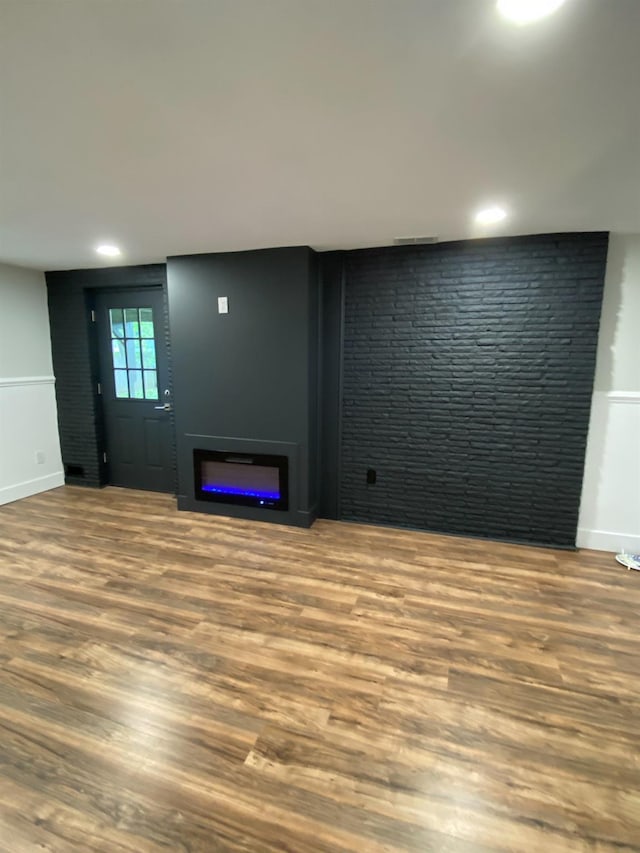 unfurnished living room featuring a glass covered fireplace, recessed lighting, and wood finished floors