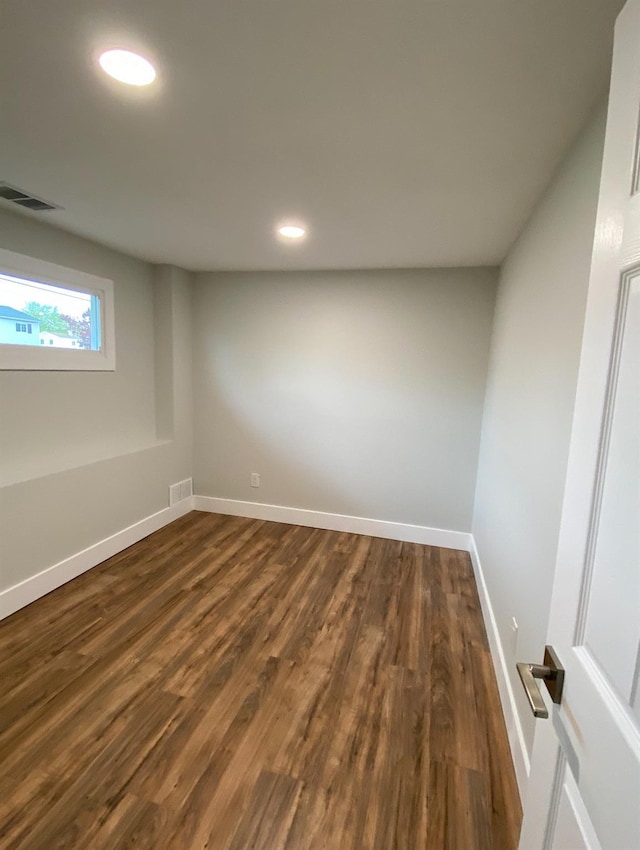 spare room with dark wood-style flooring, recessed lighting, visible vents, and baseboards