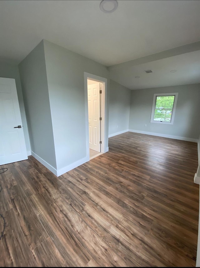 interior space featuring dark wood finished floors, visible vents, and baseboards