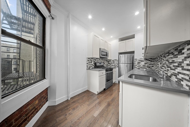 kitchen featuring dark countertops, white cabinetry, appliances with stainless steel finishes, and a sink