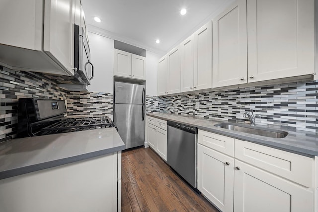 kitchen featuring white cabinets, dark countertops, dark wood-style floors, stainless steel appliances, and a sink