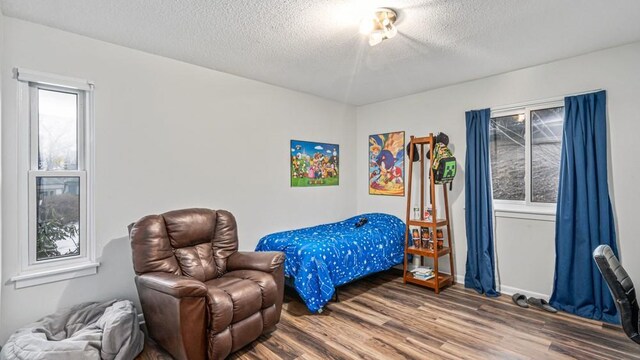 bedroom featuring a textured ceiling and wood finished floors