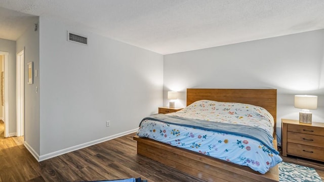 bedroom with dark wood-style flooring, visible vents, and baseboards