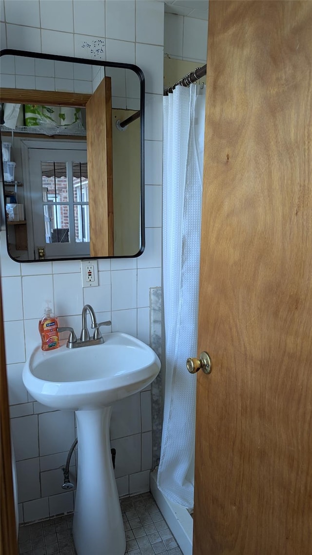 full bath with tile walls, backsplash, tile patterned flooring, and a shower stall