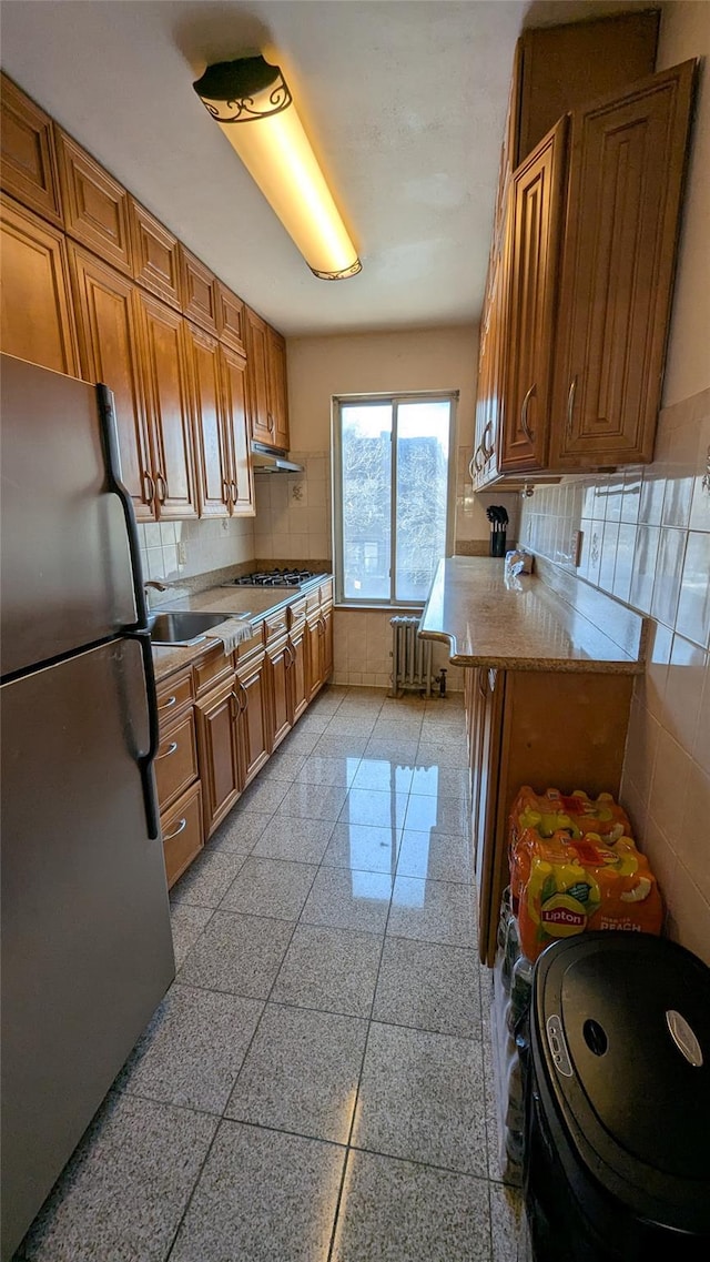 kitchen featuring stainless steel appliances, light countertops, and brown cabinets