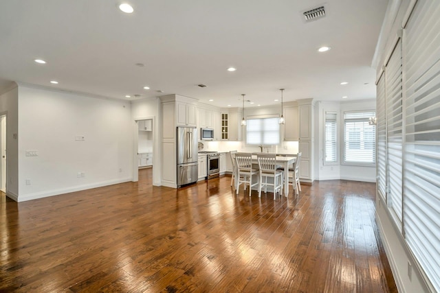 kitchen featuring visible vents, premium appliances, dark wood-style floors, glass insert cabinets, and recessed lighting