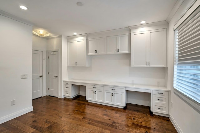 unfurnished office featuring built in desk, dark wood-type flooring, plenty of natural light, and recessed lighting