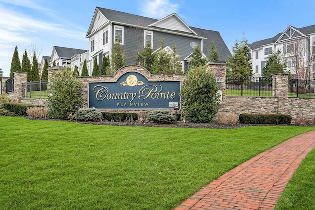 community / neighborhood sign with fence and a lawn