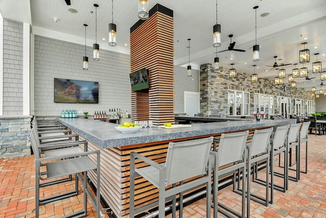 kitchen featuring brick floor, open floor plan, a ceiling fan, and decorative light fixtures