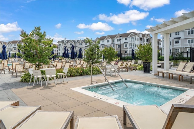 view of pool featuring a residential view, a patio area, fence, and a hot tub