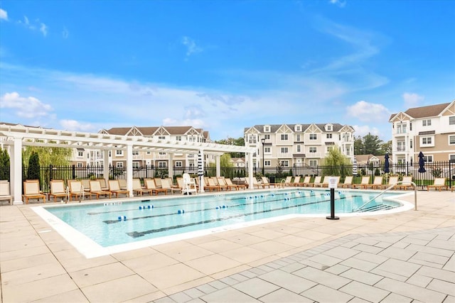 pool featuring a residential view, a patio area, fence, and a pergola